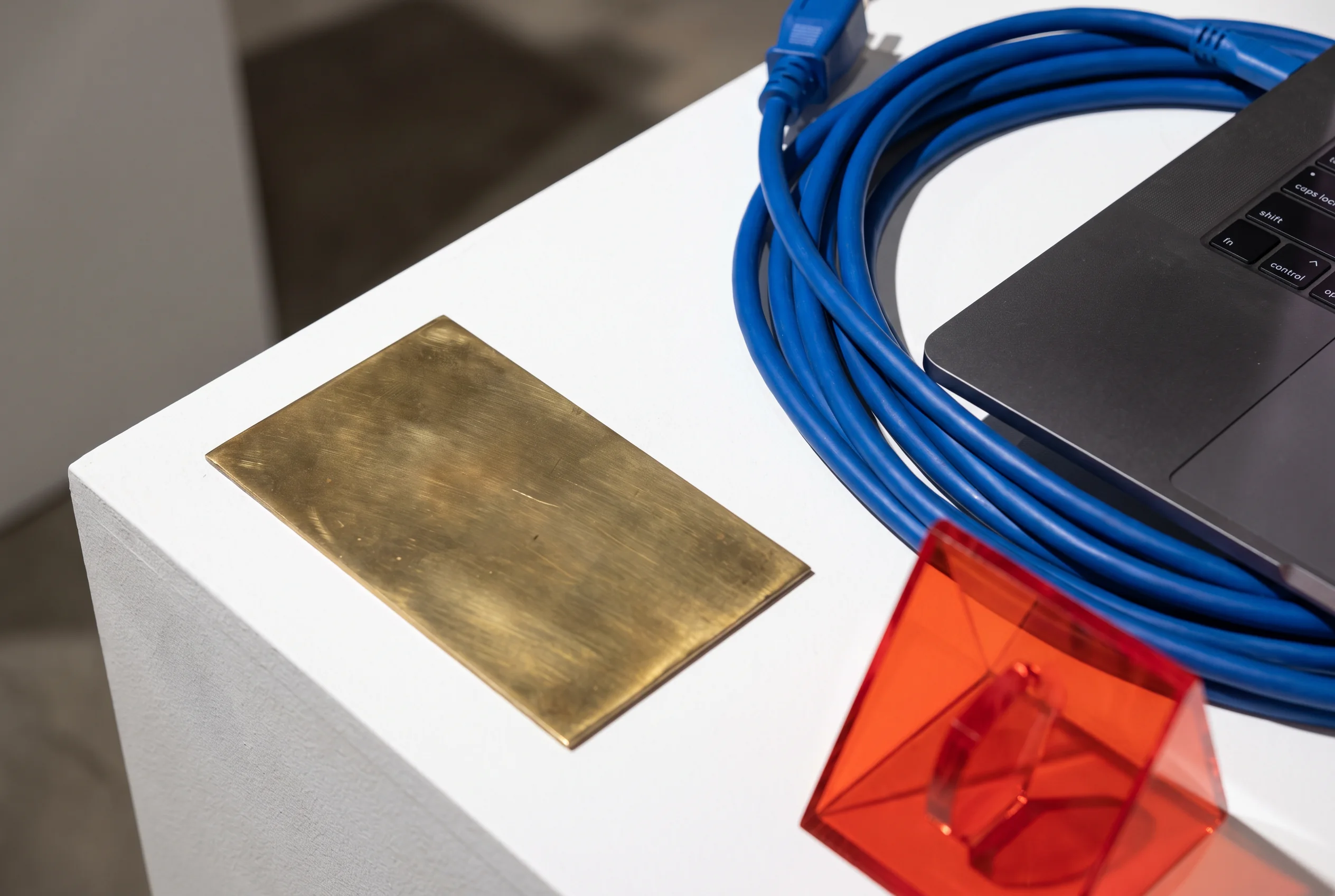 Blue cable and design objects arranged beside a laptop